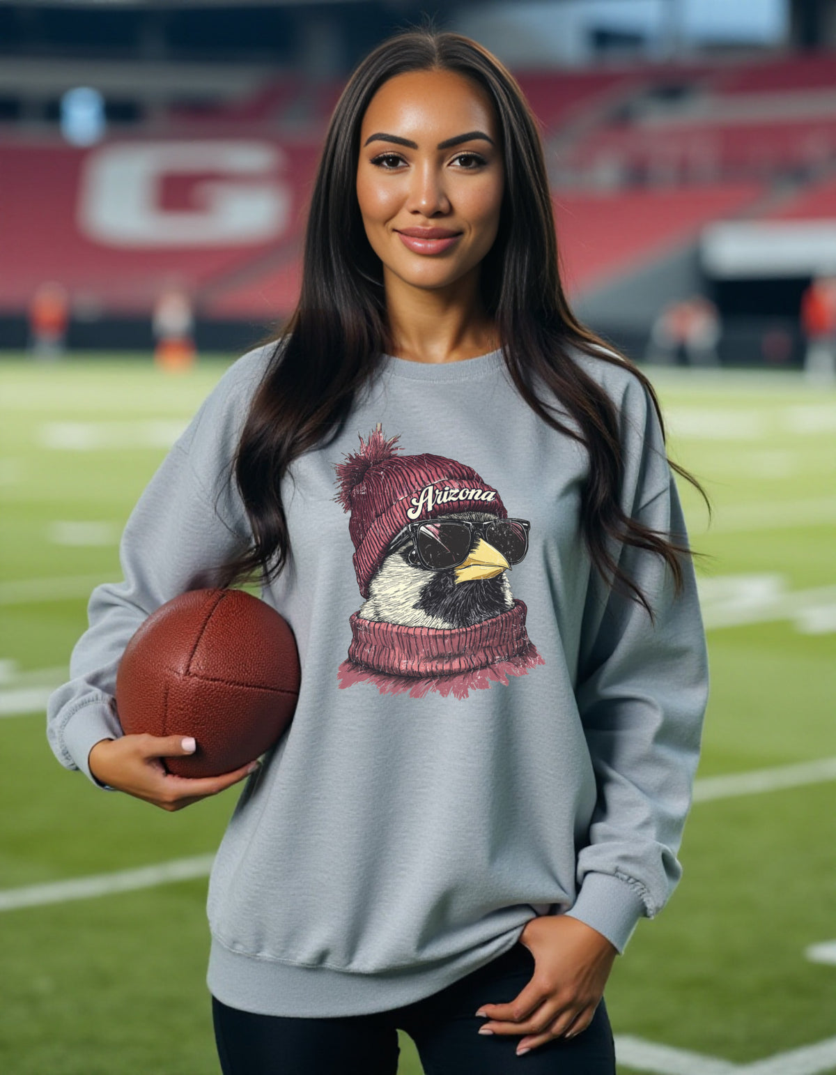 Arizona Cardinals Spirit Animal crewneck sweatshirt on a female model holding a football