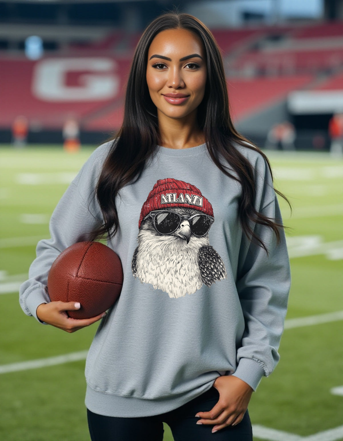 Atlanta Falcons Spirit Animal crewneck sweatshirt on a female model holding a football