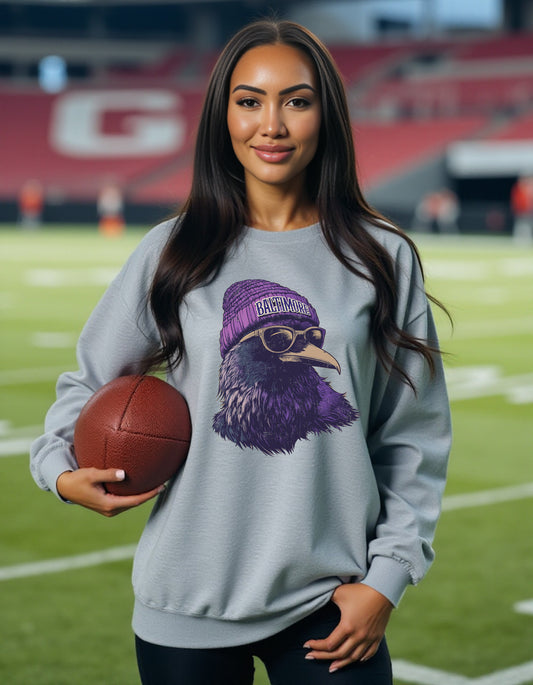 Baltimore Ravens Spirit Animal crewneck sweatshirt on a female model holding a football