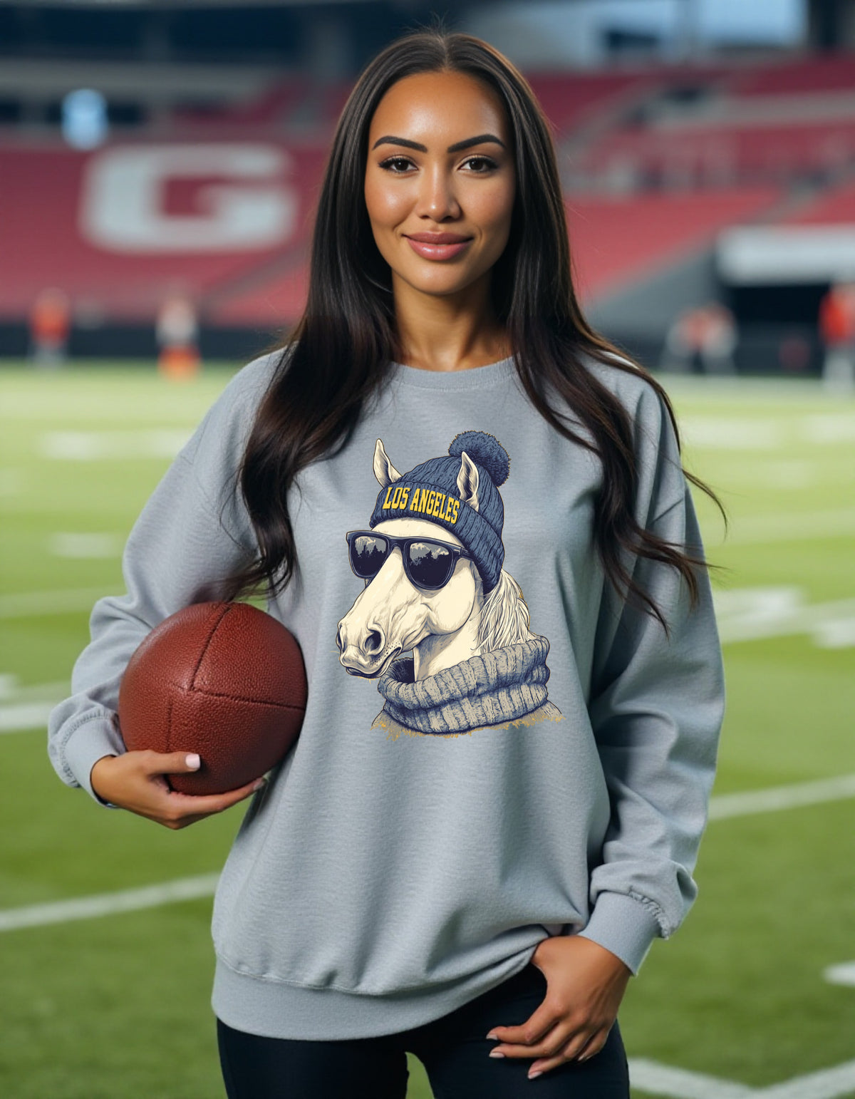 Los Angeles Chargers Spirit Animal sweatshirt on female model with football