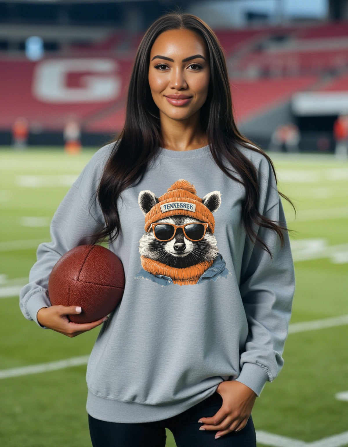 Tennessee Titans orange-hat raccoon sweatshirt modeled by woman holding football